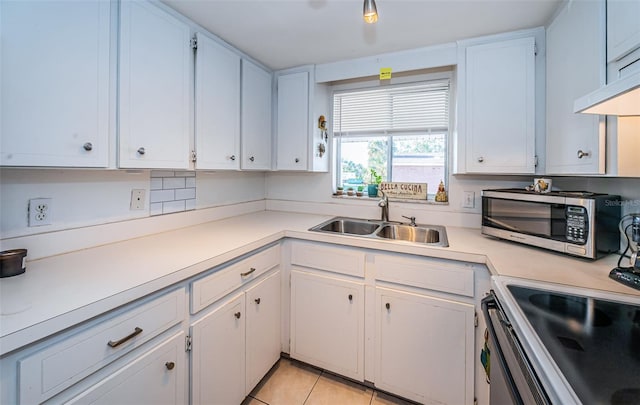 kitchen featuring light tile patterned floors, white cabinetry, and sink