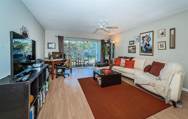 living room featuring ceiling fan, wood-type flooring, and a textured ceiling