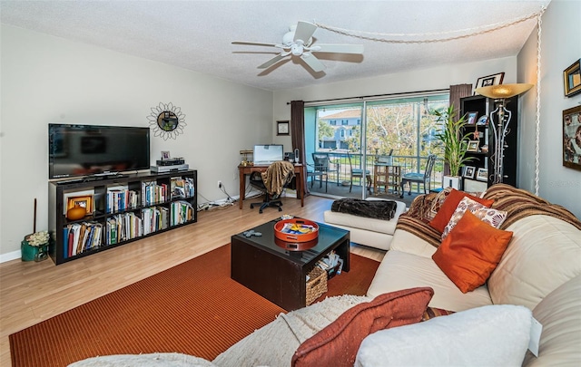 living room featuring ceiling fan, a textured ceiling, and hardwood / wood-style flooring