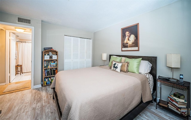 bedroom with hardwood / wood-style floors and a closet