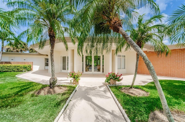 view of front of property with a front yard and french doors