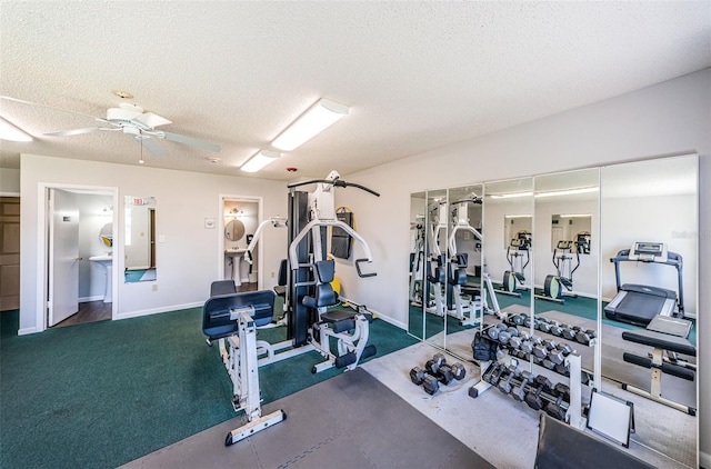 workout area featuring ceiling fan, a textured ceiling, and dark colored carpet