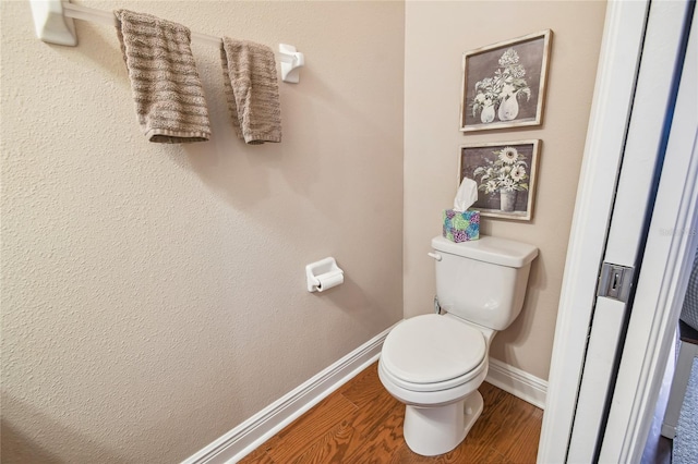 bathroom with toilet and hardwood / wood-style flooring