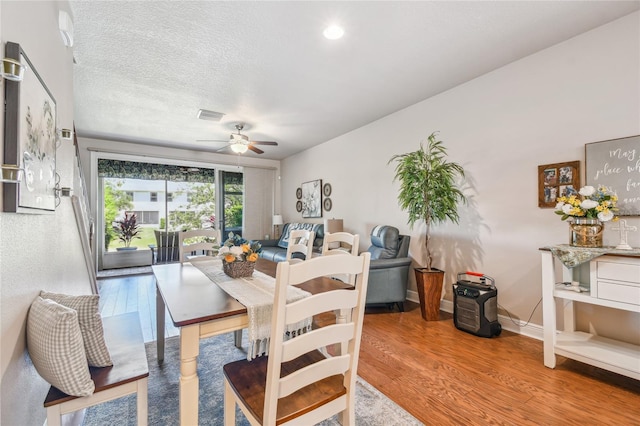 dining room featuring ceiling fan, a textured ceiling, and hardwood / wood-style flooring