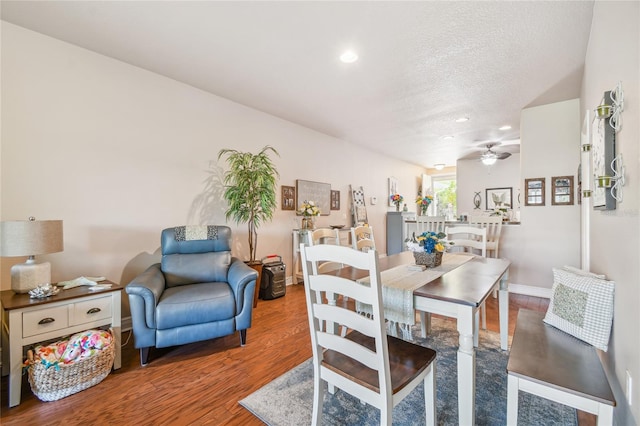 dining room featuring ceiling fan, wood-type flooring, and a textured ceiling