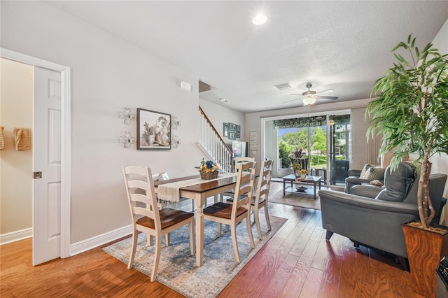 dining area featuring hardwood / wood-style floors, ceiling fan, and a textured ceiling