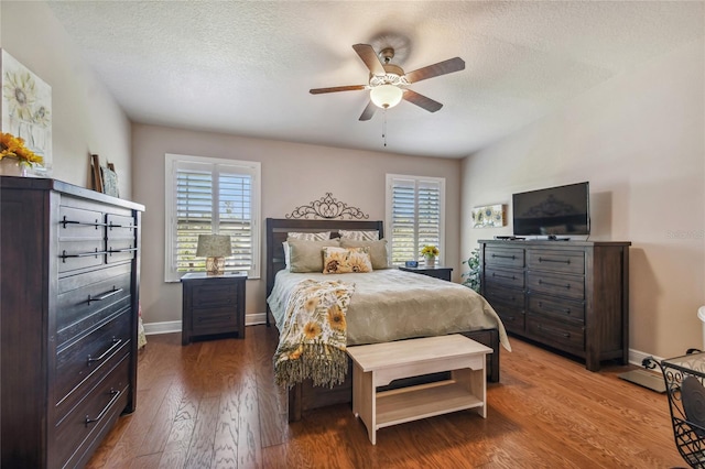 bedroom featuring multiple windows, hardwood / wood-style floors, a textured ceiling, and ceiling fan