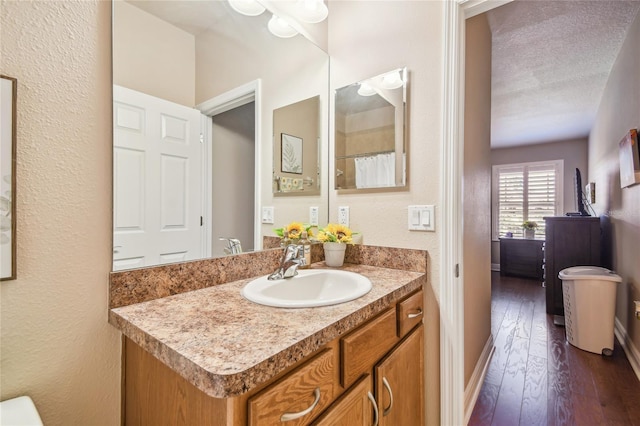 bathroom with vanity, hardwood / wood-style floors, a textured ceiling, and toilet