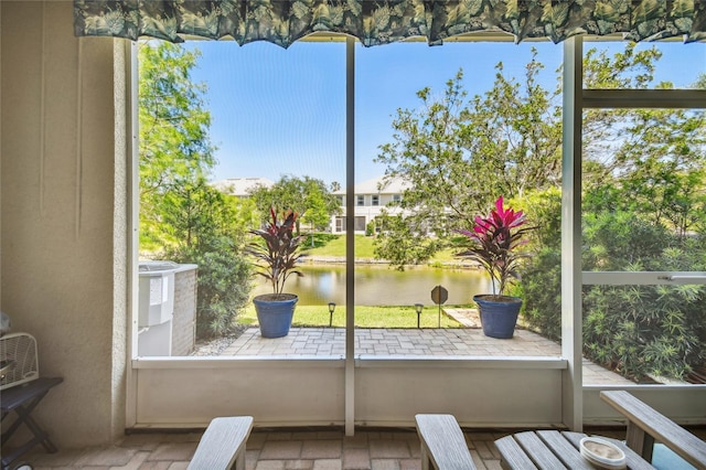 unfurnished sunroom featuring a water view