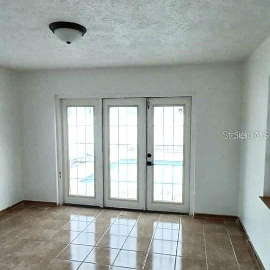 doorway featuring tile patterned flooring, french doors, and a wealth of natural light