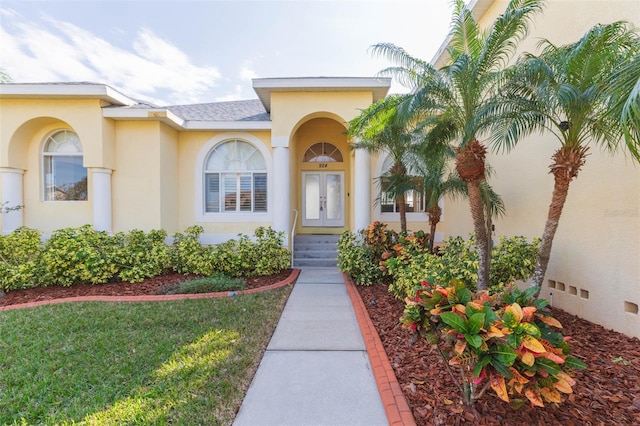 property entrance featuring french doors and a lawn