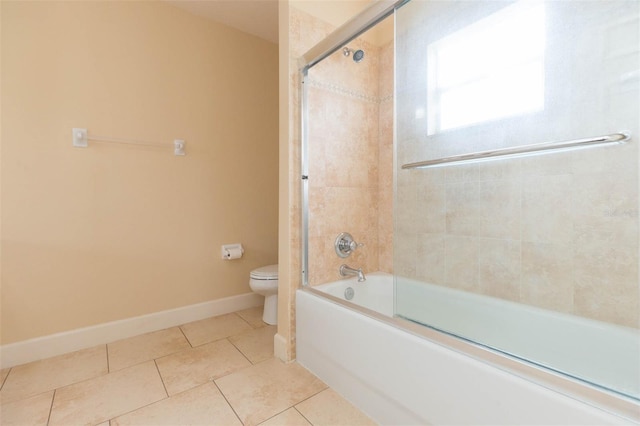 bathroom with tile patterned floors, toilet, and shower / bath combination with glass door