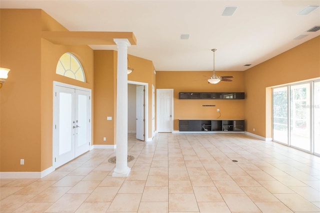 unfurnished living room featuring french doors, light tile patterned floors, ornate columns, and ceiling fan