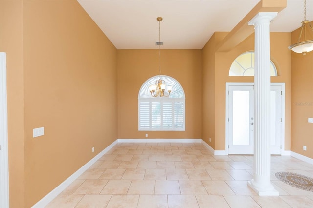 tiled entryway featuring ornate columns and an inviting chandelier