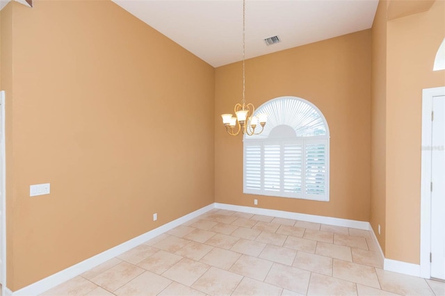 spare room featuring light tile patterned floors and a chandelier