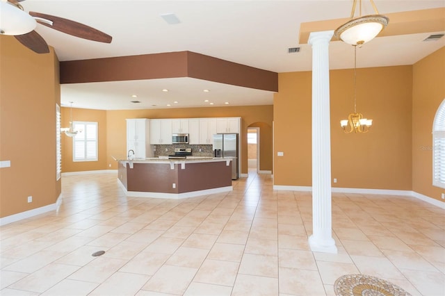 kitchen with ornate columns, white cabinetry, pendant lighting, and appliances with stainless steel finishes