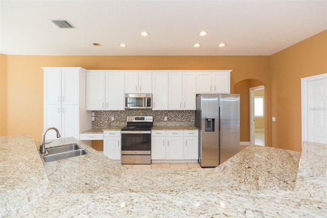 kitchen featuring backsplash, white cabinetry, sink, and appliances with stainless steel finishes