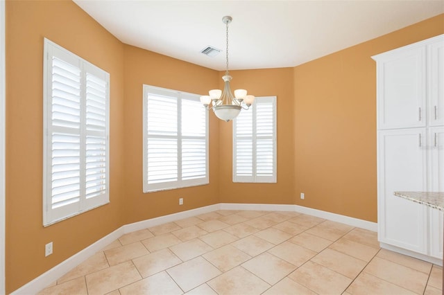 unfurnished dining area featuring light tile patterned floors and an inviting chandelier