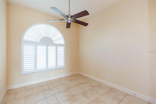 empty room featuring ceiling fan, light tile patterned floors, and lofted ceiling