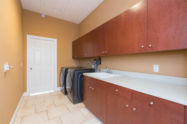 laundry area with cabinets, light tile patterned floors, washing machine and clothes dryer, and sink