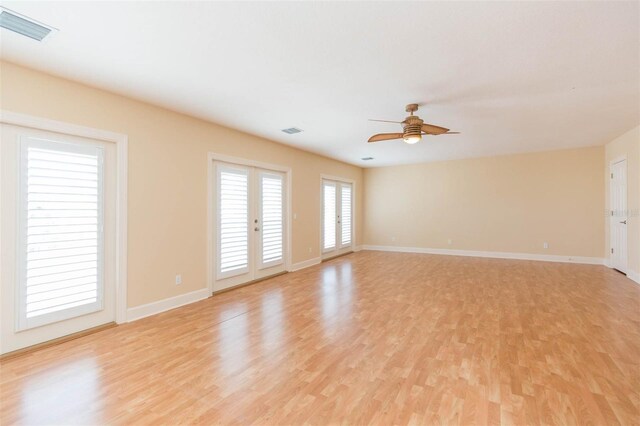 empty room featuring ceiling fan, light hardwood / wood-style flooring, and french doors