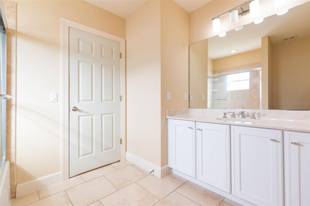 bathroom with tile patterned floors, vanity, and walk in shower