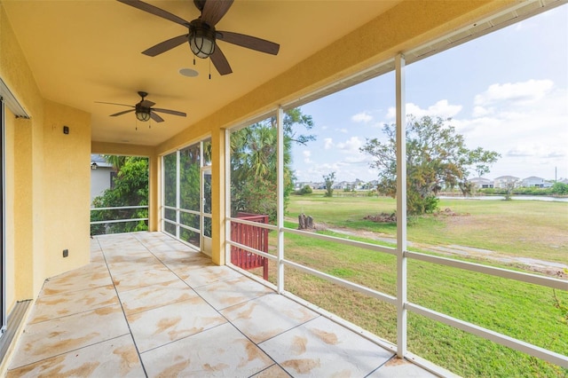 unfurnished sunroom featuring ceiling fan