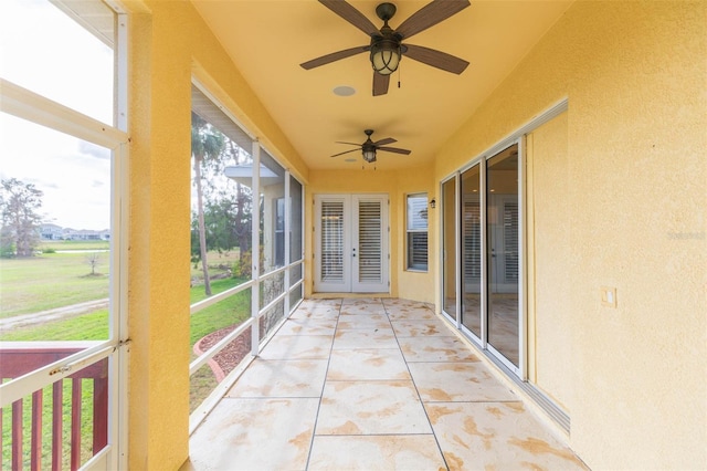 unfurnished sunroom with ceiling fan