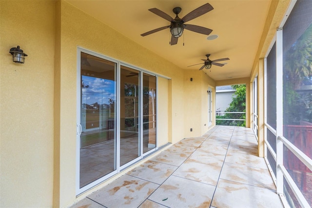 unfurnished sunroom with ceiling fan