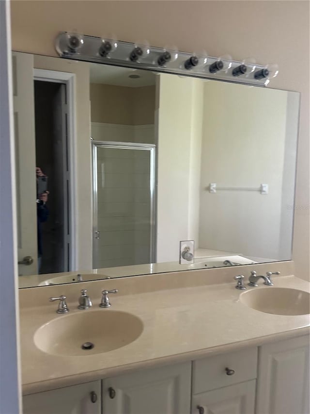 bathroom with vanity and a shower with door