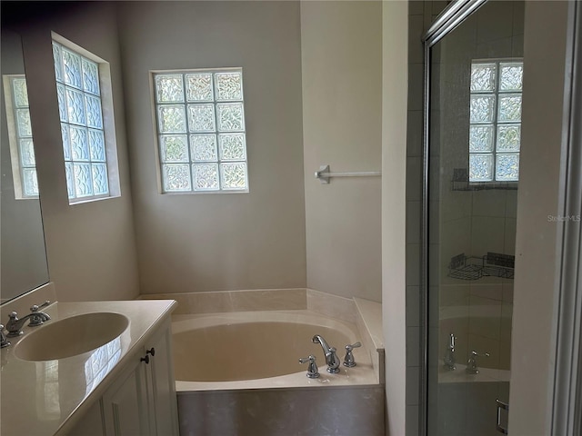 bathroom with vanity, separate shower and tub, and a healthy amount of sunlight