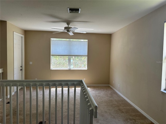 stairs featuring ceiling fan and carpet floors