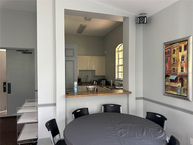 dining space with sink and vaulted ceiling