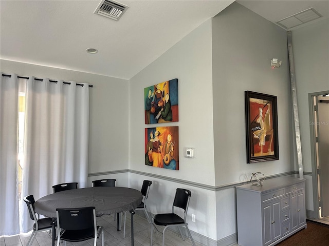 dining room with tile patterned floors and vaulted ceiling