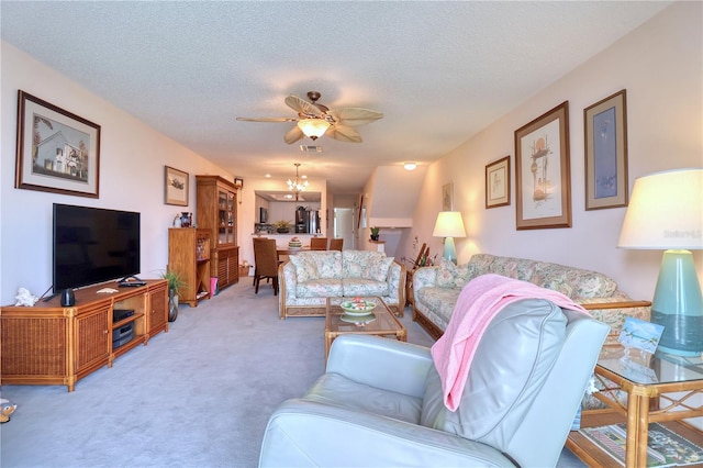 living room featuring carpet flooring, a textured ceiling, and ceiling fan with notable chandelier