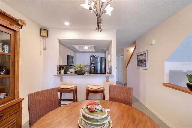 dining room featuring a chandelier and a textured ceiling