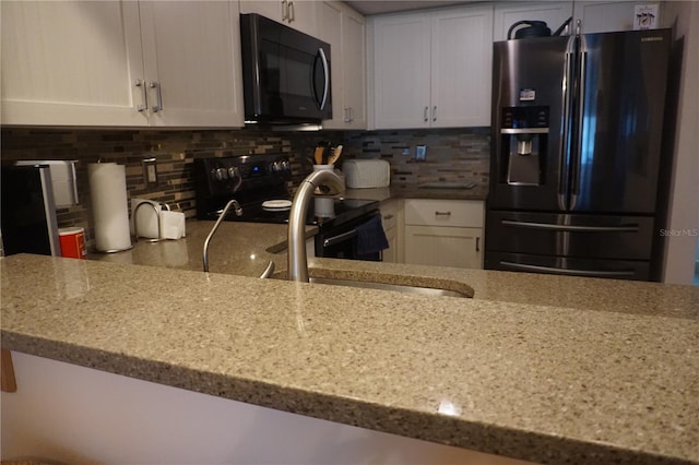 kitchen with white cabinets, appliances with stainless steel finishes, and backsplash