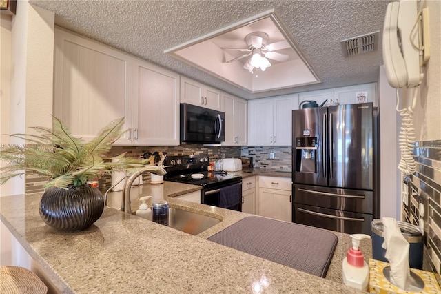 kitchen featuring a kitchen breakfast bar, sink, appliances with stainless steel finishes, tasteful backsplash, and kitchen peninsula