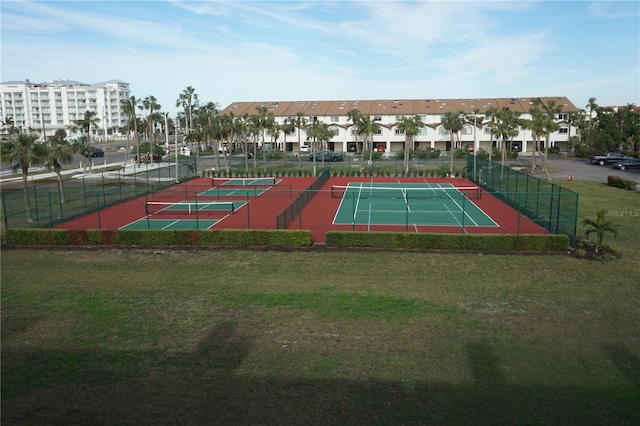 view of tennis court with a yard