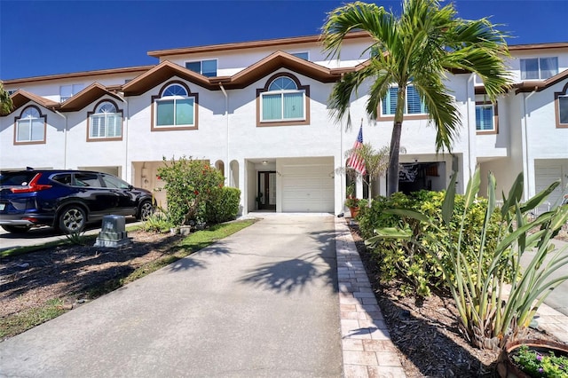 view of front of house featuring driveway, an attached garage, and stucco siding