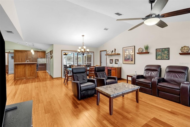 living room featuring lofted ceiling, ceiling fan with notable chandelier, and light wood-type flooring