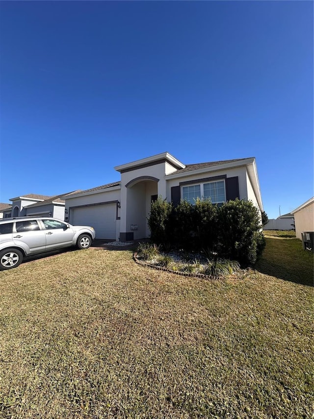 view of front of property with a garage and a front lawn