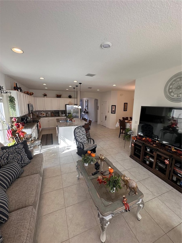 tiled living room featuring sink and a textured ceiling