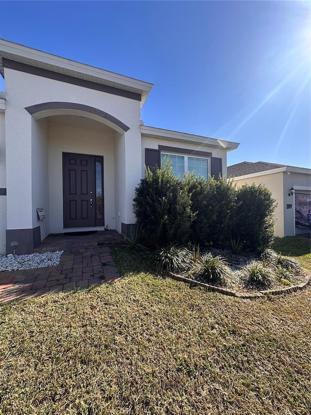 doorway to property featuring stucco siding