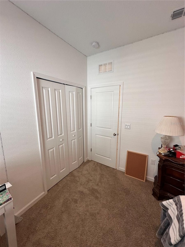 unfurnished bedroom with a closet, visible vents, and carpet flooring