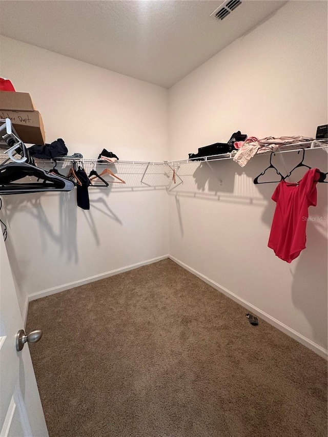 walk in closet with visible vents and dark colored carpet