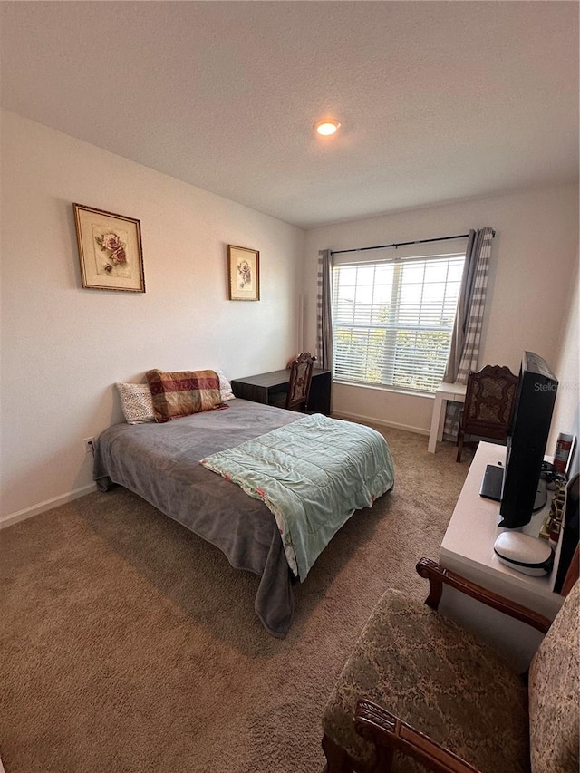 carpeted bedroom with a textured ceiling and baseboards