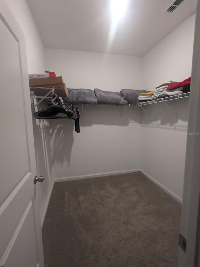 walk in closet featuring visible vents and dark carpet