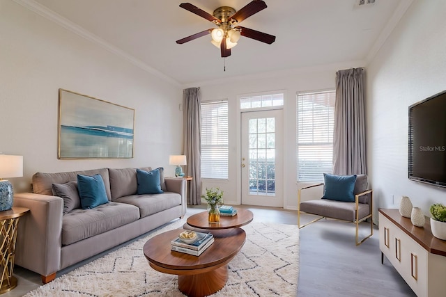 living area with ceiling fan, visible vents, crown molding, and wood finished floors