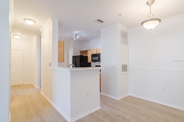 kitchen featuring light brown cabinets, light wood-style flooring, a peninsula, visible vents, and black appliances